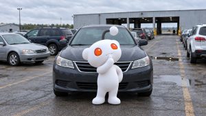 Illustration of a thinking Reddit character standing in front of a gray car at an auto auction.
